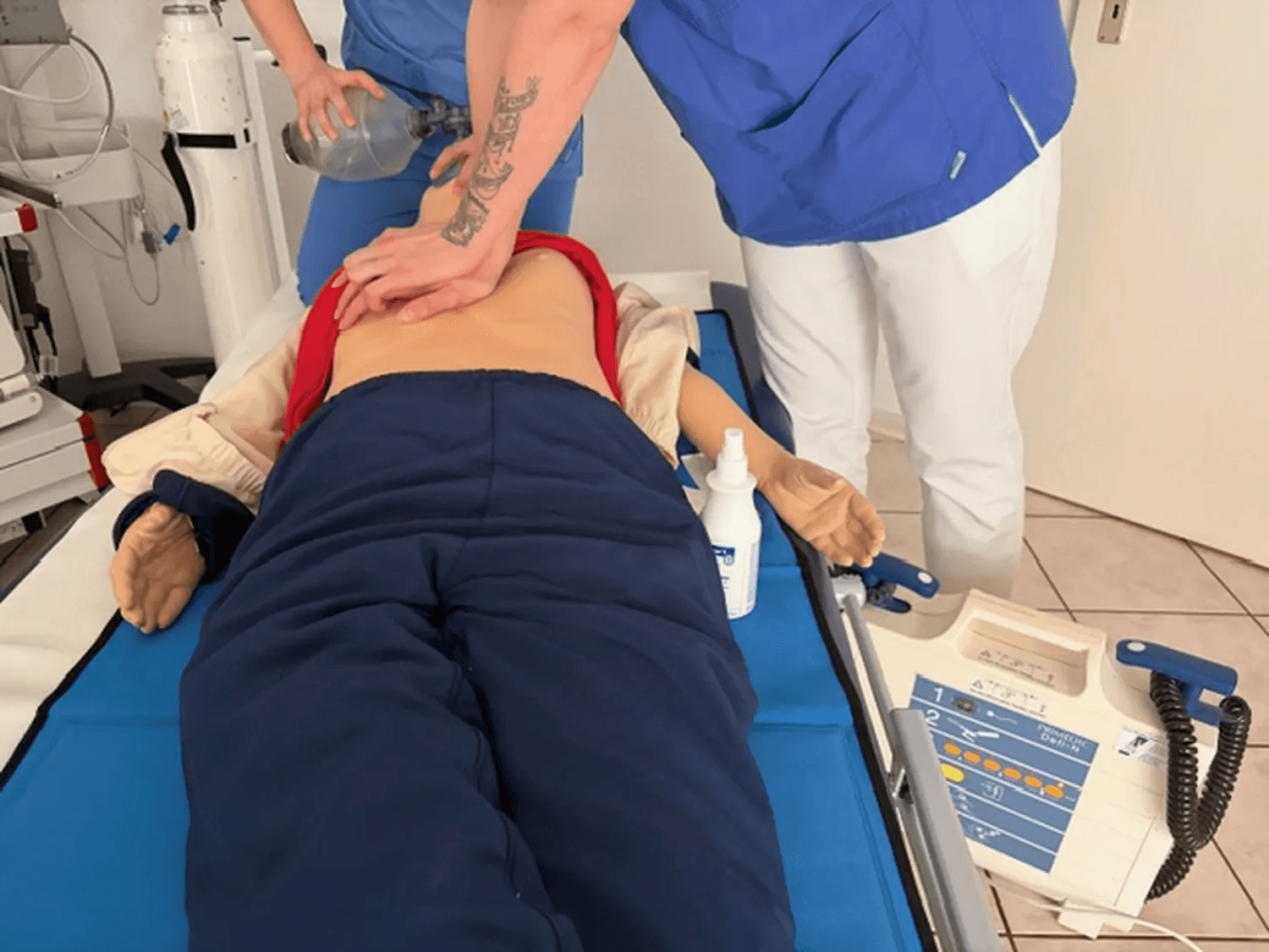 Zwei Personen aus dem Klinikpersonal führen gemeinsam Beatmung und Herzdruckmassage an einem Phantom durch