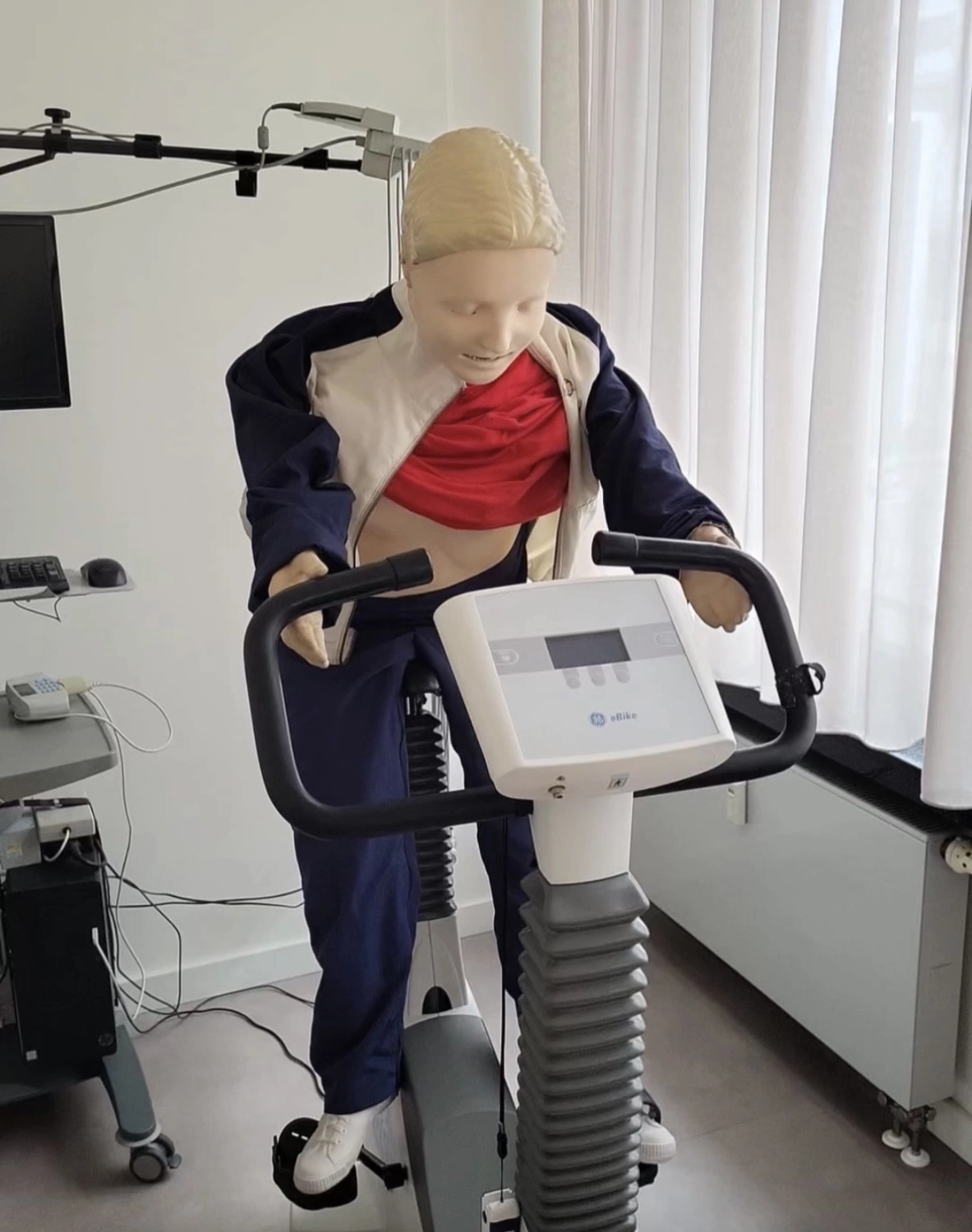 Team Herzdruck – Notfallworkshops – Dieses Bild zeigt eine medizinische Übungspuppe auf einem Fahrradergometer. Team Herzdruck – Notfall-Workshops –