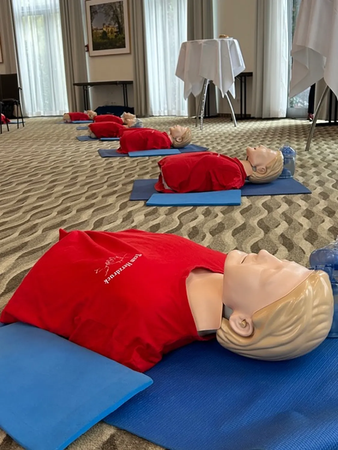 Team Herzdruck – Notfall-Workshops – Dieses Bild zeigt eine Reanimationsübung, bei der die Teilnehmenden die Herzdruckmassage an Übungspuppen erlernen.